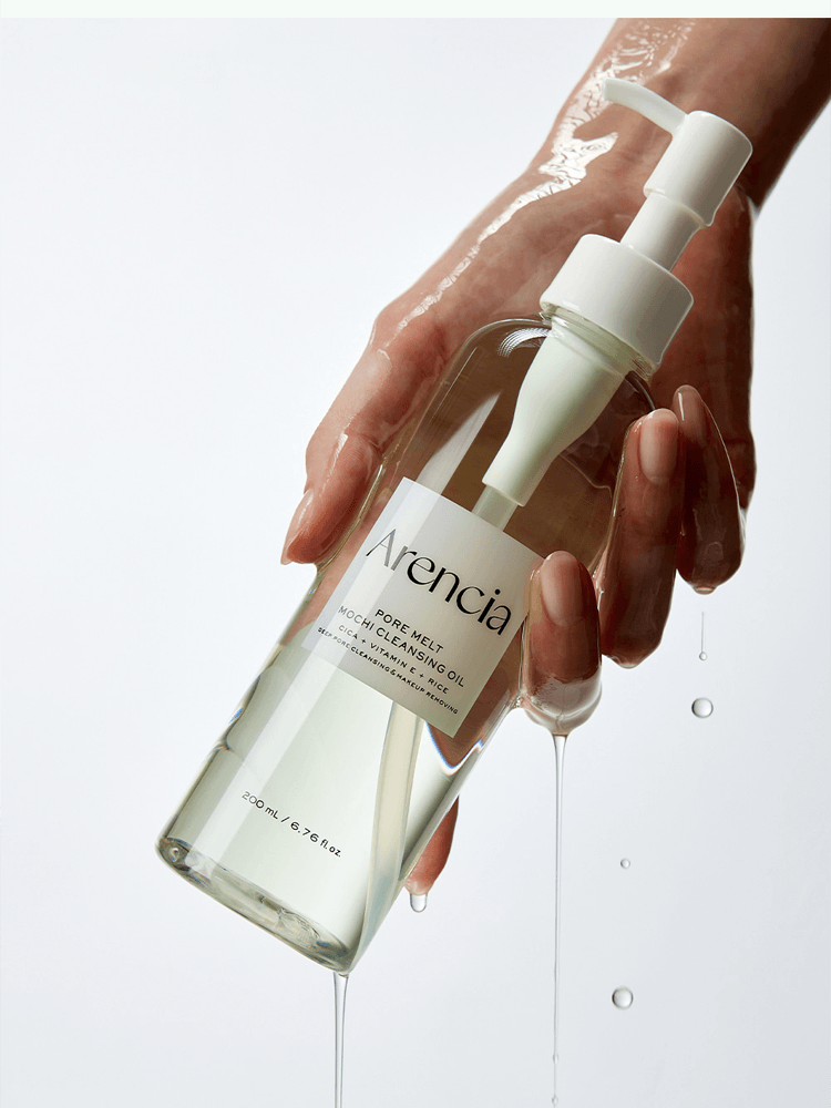 ARENCIA Pore Melt Mochi Cleansing Oil 200ml being dispensed from a pump, showing a hand holding the bottle.