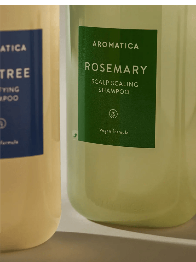 AROMATICA Rosemary Scalp Scaling Shampoo bottle displayed with other hair care products.
