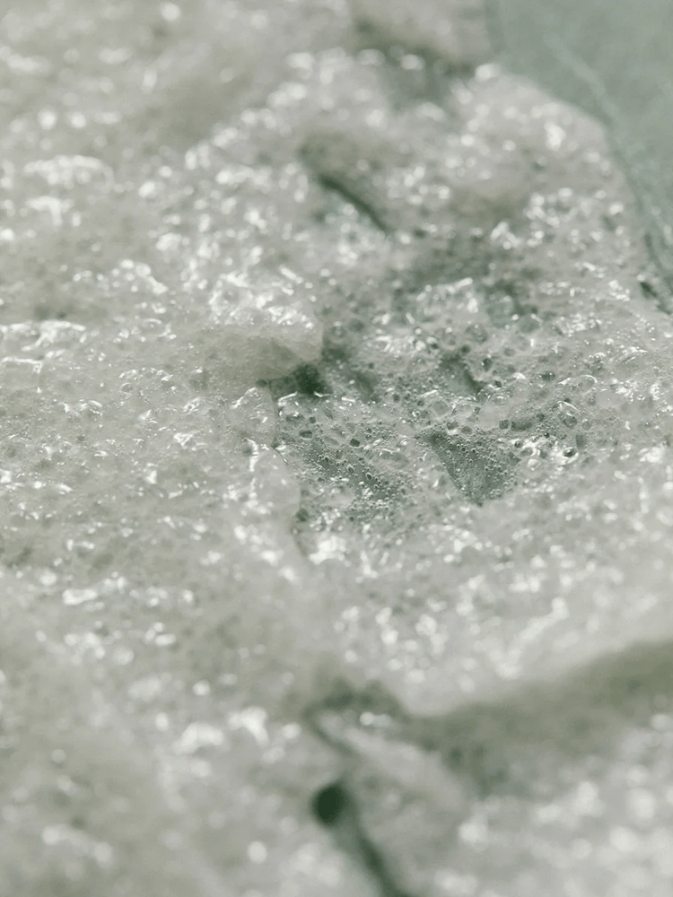 Close-up of AROMATICA Rosemary Scalp Scrub showing its foamy texture and exfoliating properties.