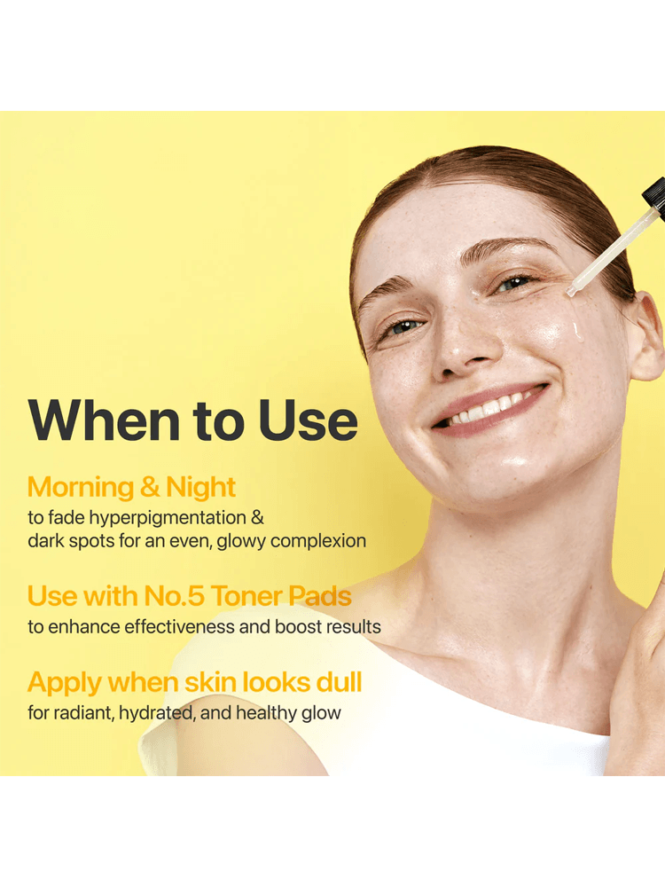 A smiling woman applying NUMBUZIN No.5 Vitamin Concentrated Serum for a glowing complexion on a yellow background.