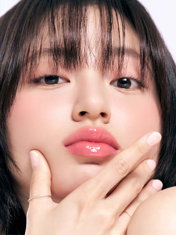 Close-up of a model's face showcasing glossy lips with rom&nd The juicy lasting tint Mini 1g.