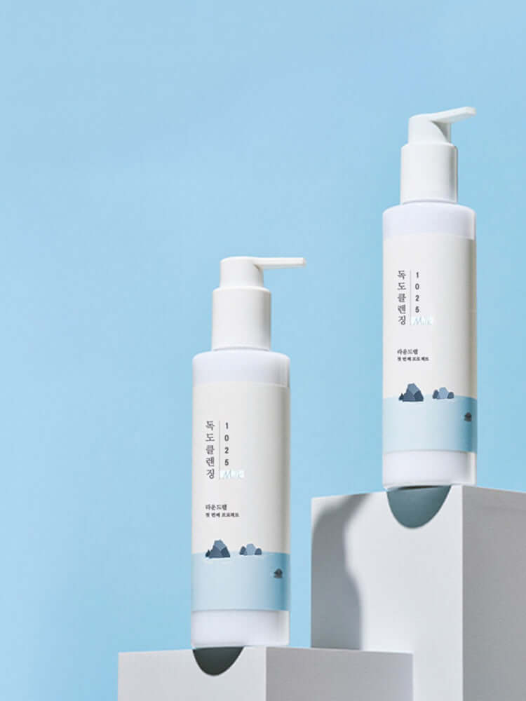 ROUND LAB 1025 Dokdo Cleansing Milk 200ml bottles against a blue background.