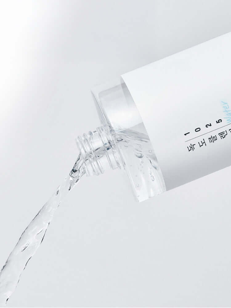 ROUND LAB 1025 Dokdo Cleansing Water 400ml pouring from the bottle, showcasing its clear, gentle formula.