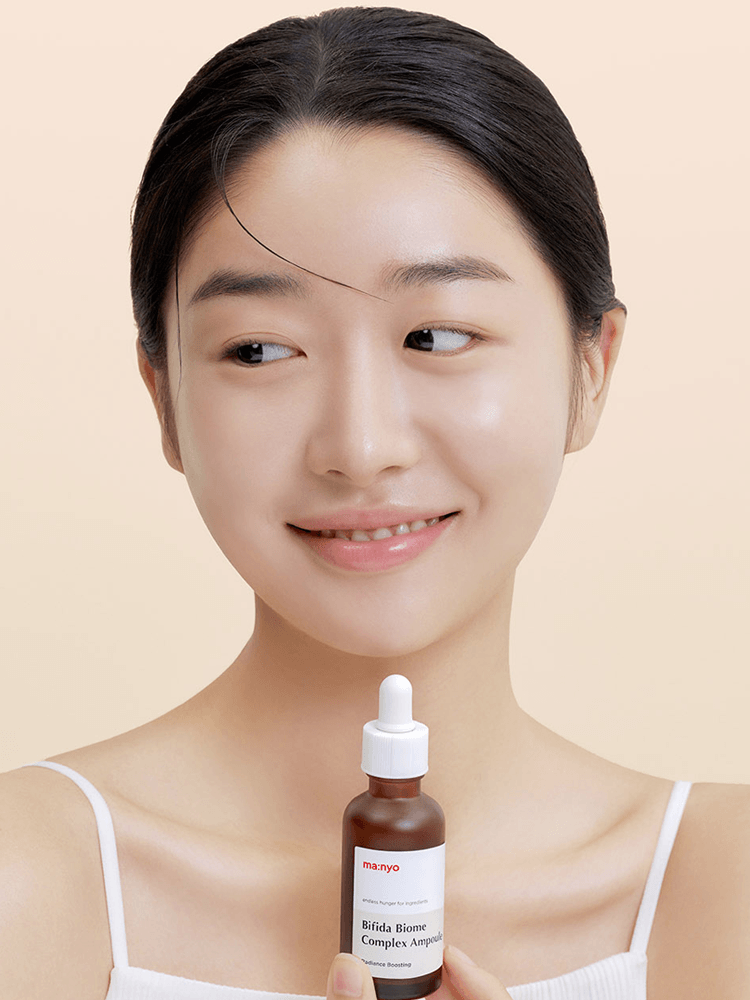Model holding manyo Bifida Biome Complex Ampoule, demonstrating radiant skin and hydration benefits.