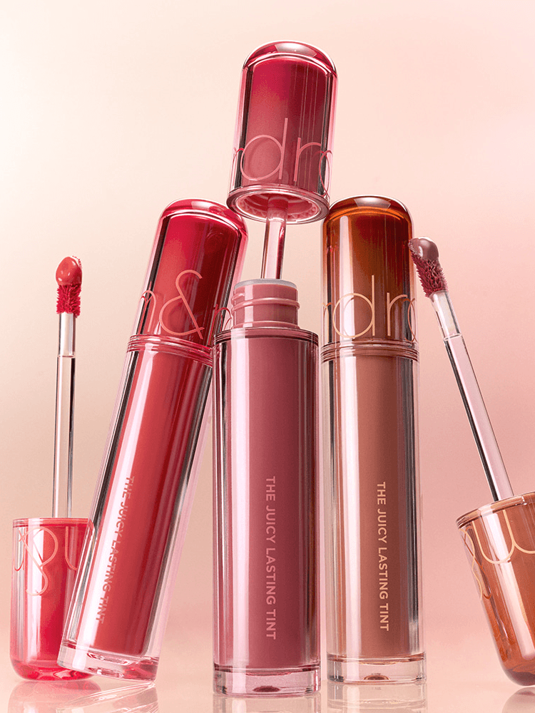 romnd The Juicy Lasting Tint NEW WARM collection featuring glossy lip tints in diverse colors and applicators.